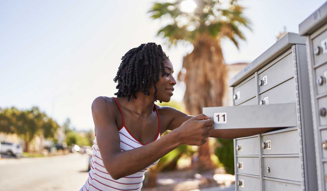 woman checking mail with smile